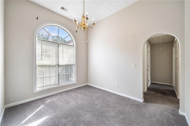 carpeted spare room featuring baseboards, visible vents, vaulted ceiling, and attic access