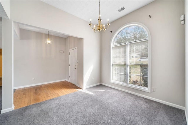 interior space with carpet, baseboards, visible vents, and a notable chandelier