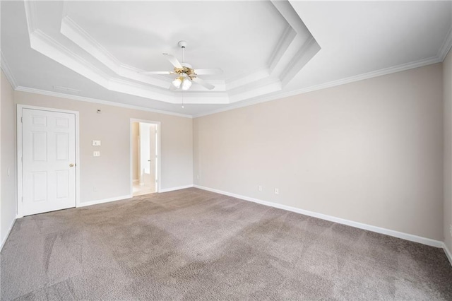 carpeted empty room featuring crown molding, a tray ceiling, ceiling fan, and baseboards