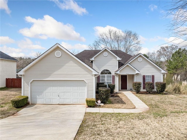 traditional home with a garage, driveway, a front lawn, and fence