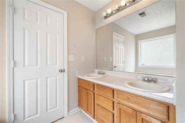 bathroom featuring double vanity, visible vents, and a sink