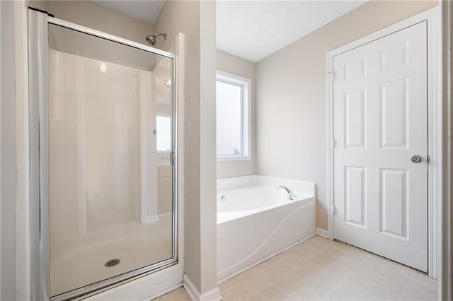 full bathroom with baseboards, a stall shower, a garden tub, and tile patterned floors