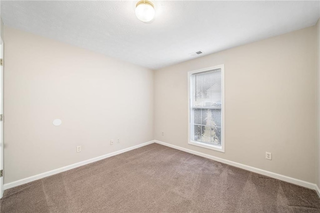 carpeted spare room with baseboards and visible vents