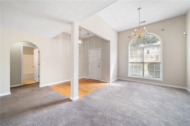 interior space with arched walkways, visible vents, baseboards, and an inviting chandelier