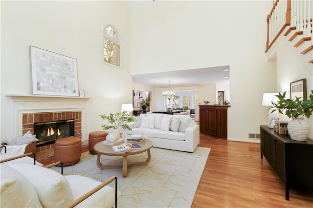 3711 Spinnaker Cir, Alpharetta, GA 30005 - living room featuring a high ceiling, light wood-style floors, a chandelier, a fireplace, and baseboards