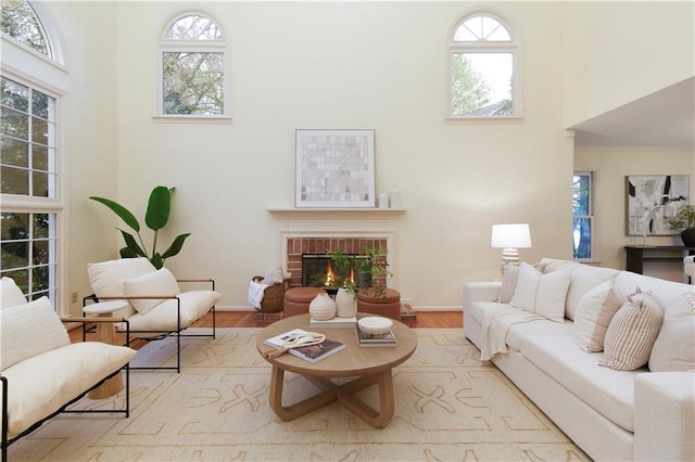 3711 Spinnaker Cir, Alpharetta, GA 30005 - living area featuring a towering ceiling, a fireplace, wood finished floors, and baseboards