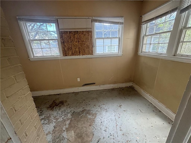 spare room featuring baseboards and a wealth of natural light