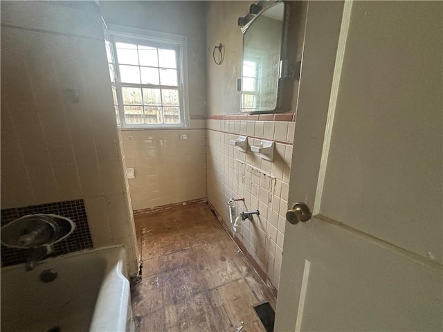 full bathroom with wainscoting, tile walls, and a bath