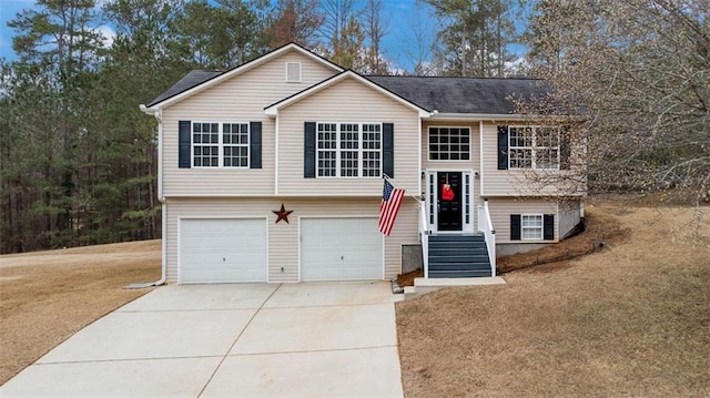 split foyer home with a garage, a front lawn, and driveway