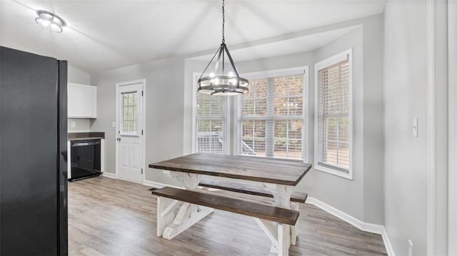 dining area featuring a chandelier, baseboards, and light wood-style floors