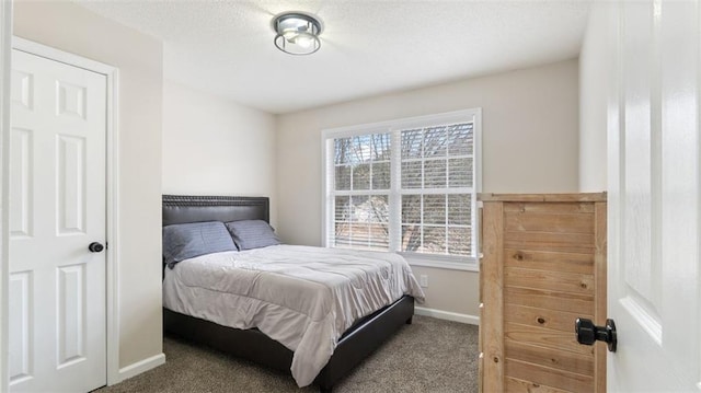 carpeted bedroom featuring baseboards and a textured ceiling