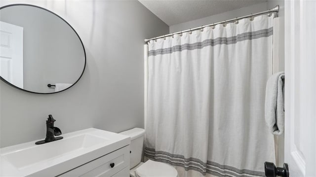 full bathroom featuring toilet, a textured ceiling, vanity, and a shower with curtain