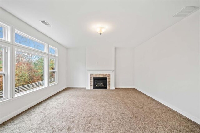 unfurnished living room with carpet and a brick fireplace