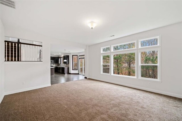 unfurnished living room featuring dark colored carpet