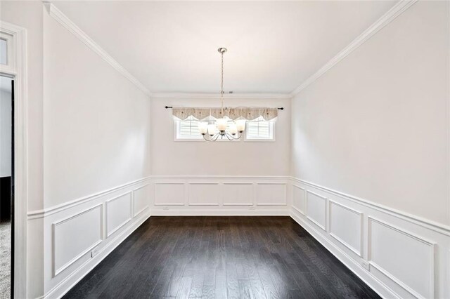 unfurnished dining area featuring dark hardwood / wood-style flooring, an inviting chandelier, and ornamental molding