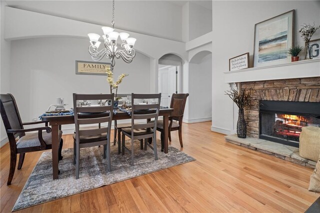 216 Crescent Moon Way, Canton, GA 30114 - dining room with a fireplace, wood finished floors, arched walkways, and a chandelier