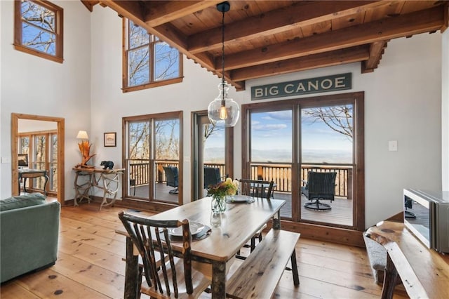 dining space featuring light wood-type flooring, beam ceiling, and wooden ceiling