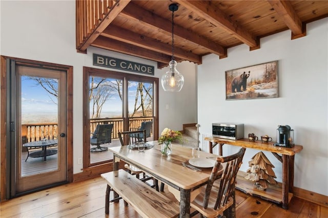 dining area with light wood-type flooring, wood ceiling, baseboards, and beamed ceiling