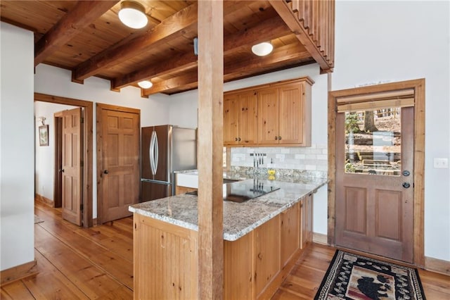 kitchen featuring wooden ceiling, decorative backsplash, light wood finished floors, and freestanding refrigerator