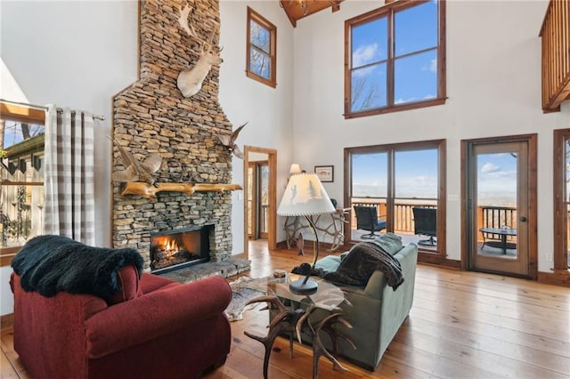 living room featuring a fireplace, baseboards, and hardwood / wood-style floors