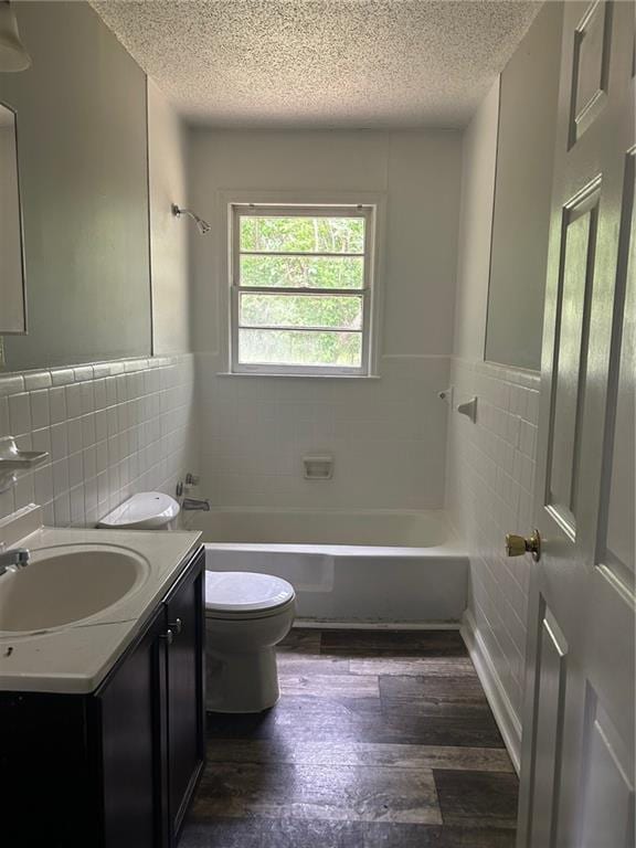 319 Gordon St, Rockmart, GA 30153 - full bathroom featuring tile walls, hardwood / wood-style flooring, toilet, and a textured ceiling