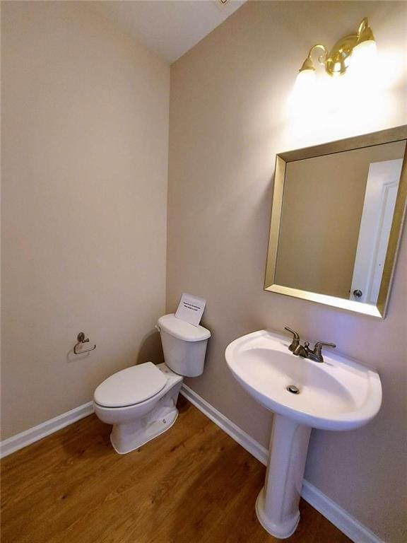 bathroom with wood-type flooring and toilet