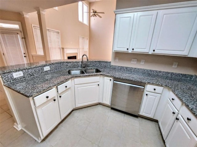 kitchen with kitchen peninsula, sink, white cabinets, and stainless steel dishwasher