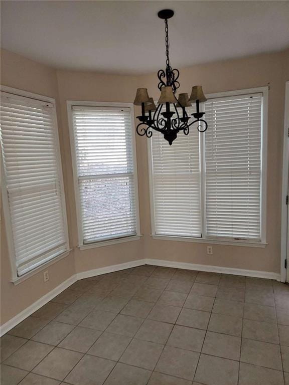 unfurnished dining area featuring a notable chandelier and light tile patterned floors