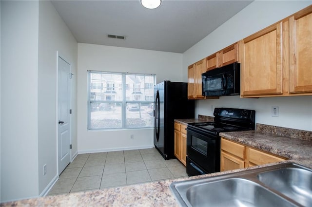 kitchen featuring light tile patterned floors, a sink, visible vents, black appliances, and dark countertops