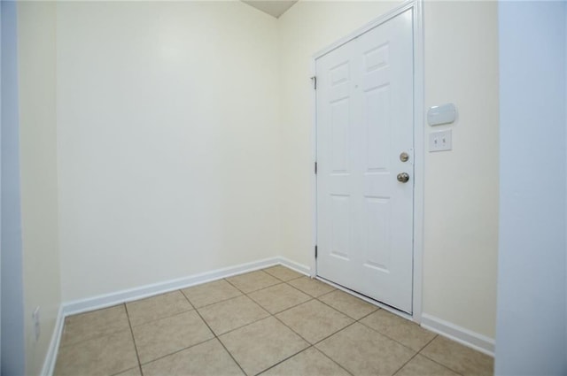 doorway to outside featuring light tile patterned floors and baseboards