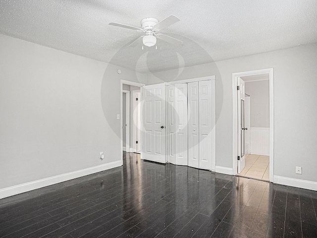 unfurnished bedroom featuring a closet, dark hardwood / wood-style floors, and a textured ceiling