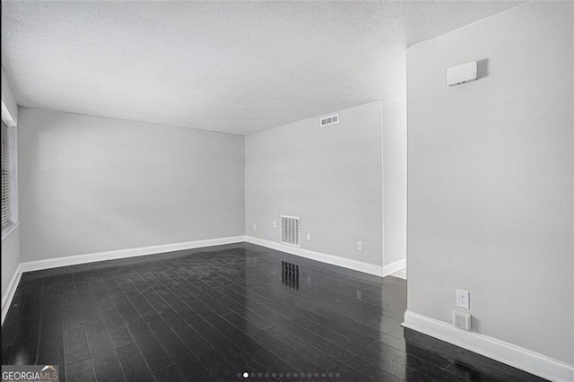 unfurnished room featuring dark hardwood / wood-style floors and a textured ceiling