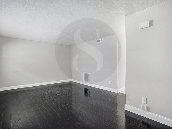 unfurnished room featuring dark hardwood / wood-style floors and a textured ceiling