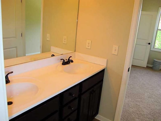 bathroom featuring double vanity and baseboards
