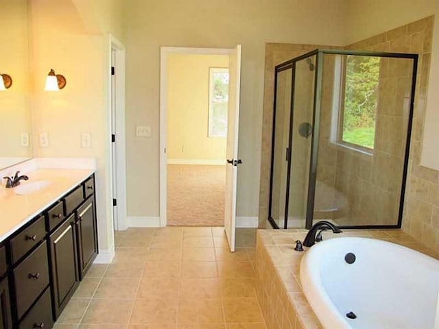 bathroom featuring a shower stall, a garden tub, tile patterned floors, vanity, and baseboards