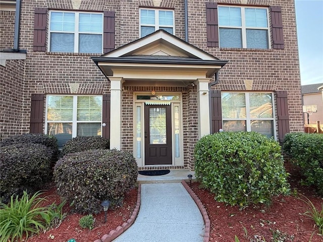 entrance to property featuring brick siding