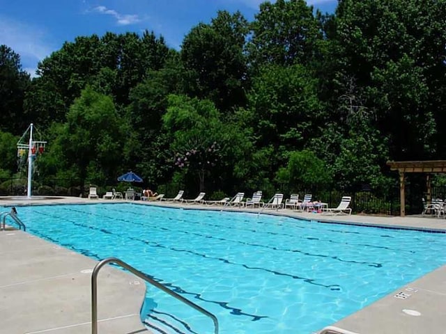 community pool featuring a patio and fence