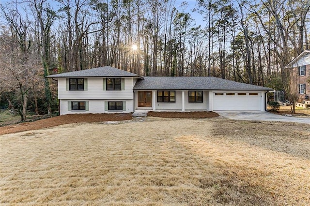 tri-level home featuring a garage, driveway, and a front lawn