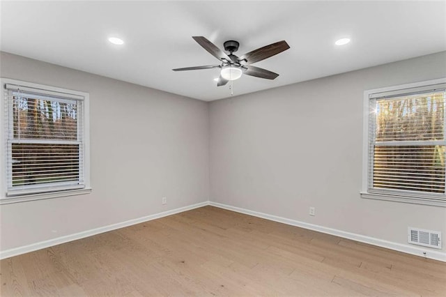 empty room featuring light wood finished floors, recessed lighting, visible vents, a ceiling fan, and baseboards