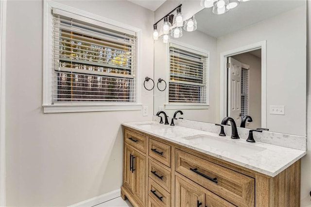 bathroom featuring double vanity, baseboards, and a sink