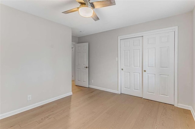 unfurnished bedroom with light wood-style floors, baseboards, and a closet