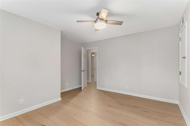 unfurnished room with light wood-type flooring, a ceiling fan, and baseboards