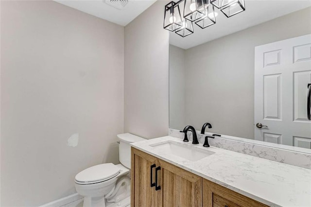 bathroom featuring toilet, a notable chandelier, visible vents, vanity, and baseboards