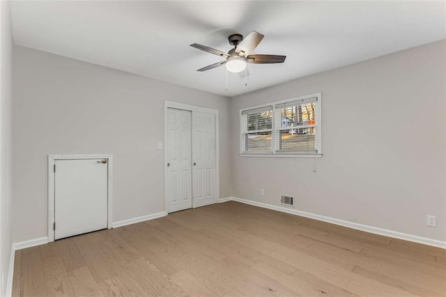 unfurnished bedroom featuring light wood-style floors, visible vents, ceiling fan, and baseboards