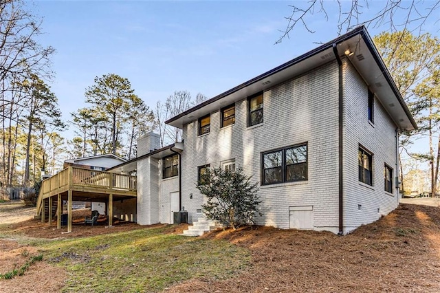 back of house featuring brick siding, a wooden deck, and central air condition unit