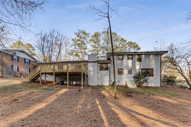 rear view of house with stairs, a deck, and a chimney