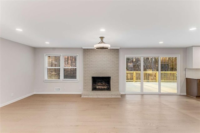 unfurnished living room featuring a fireplace, recessed lighting, visible vents, light wood-type flooring, and baseboards