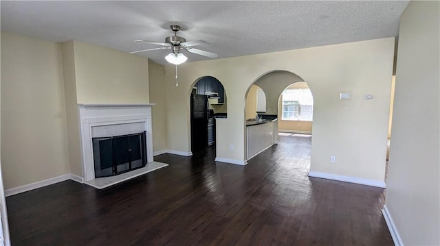 4707 Golod Way, Lithonia, GA 30038 - unfurnished living room with arched walkways, a ceiling fan, dark wood finished floors, and a fireplace with raised hearth