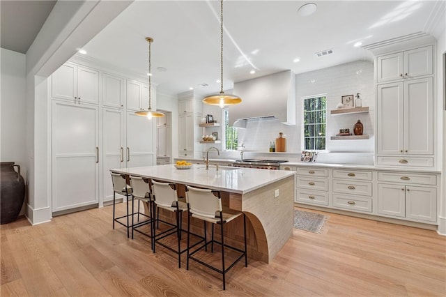 kitchen featuring visible vents, light countertops, a sink, and open shelves