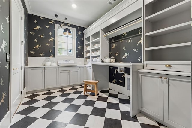 kitchen featuring open shelves, a sink, wallpapered walls, and dark floors